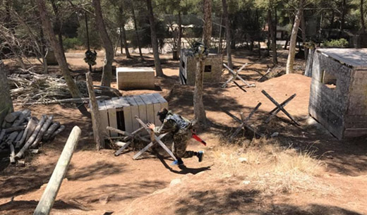 Joueurs en pleine partie de Paintball courant entre les obstacles chez Paintball Family à  Toulon