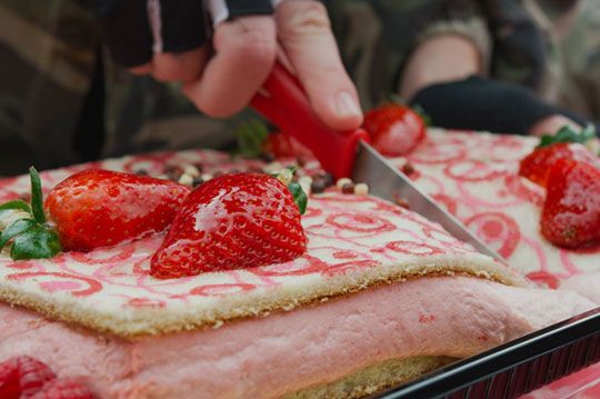 Gros plan de la découpe d'un gâteau d'anniversaire à  la fraise
