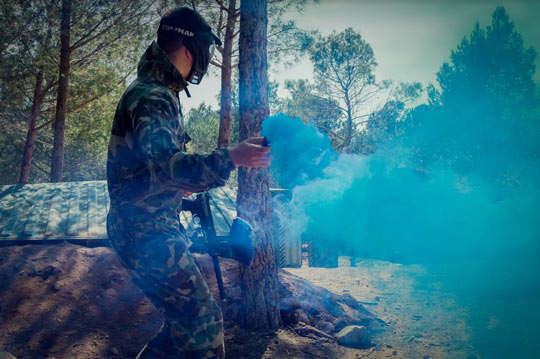 Joueur de paintball avec un fumigène dans la plaine de Grimaud