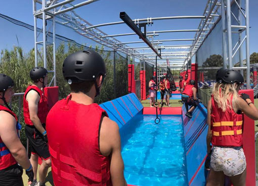 Groupe de jeunes s'amusant sur le parcours d'obstacles dans l'ambiance Ninja Warrior