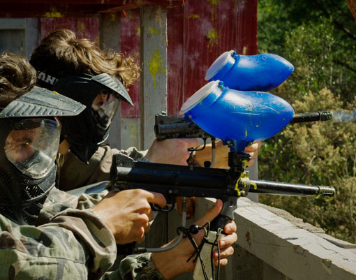 Deux joueurs s'entrainnent à  tirer sur des cibles zombie avec des fusils de paintball